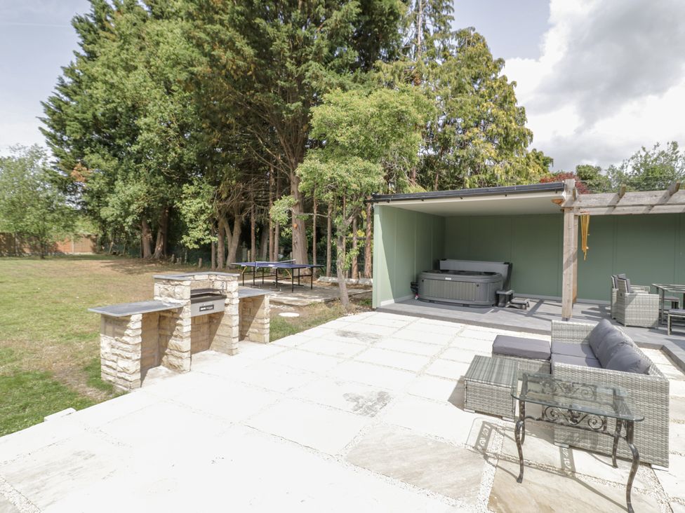 An outdoor area with a jacuzzi and seating at Chillon in South Littleton near Honeybourne