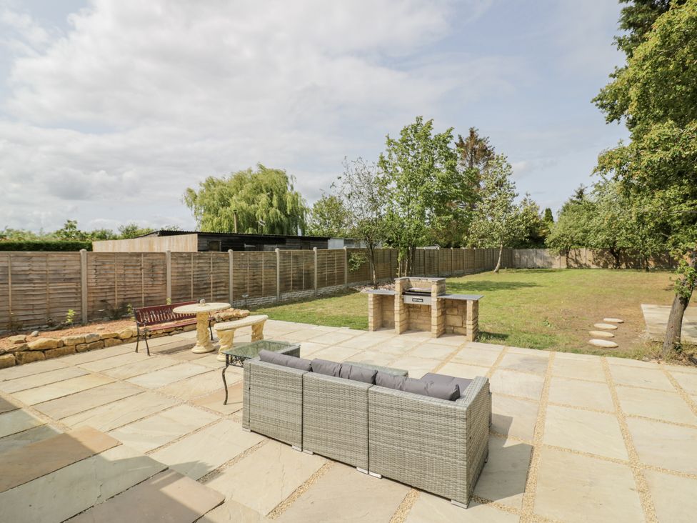 A garden with a patio, barbecue, and furniture at Chillon, South Littleton near Honeybourne