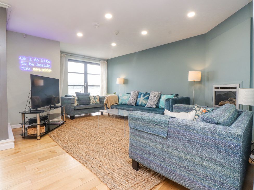 A living room with a sofa and television at 2 The Quay in Pentraeth