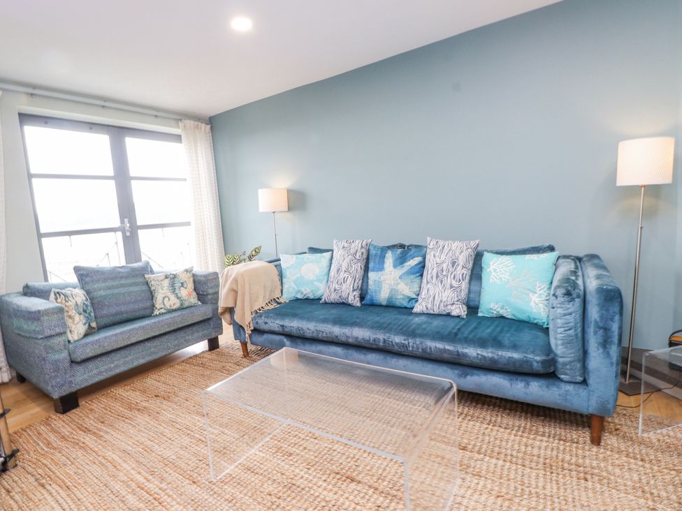 A living room with a sofa and armchair at 2 The Quay Pentraeth