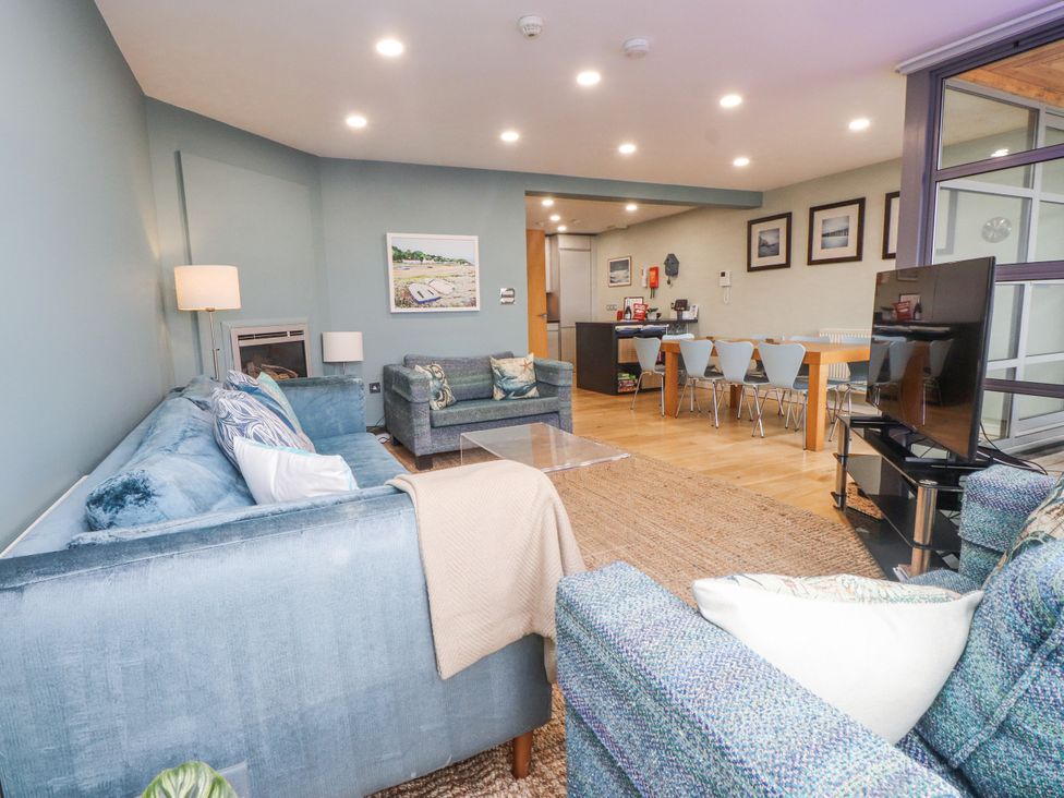 A living room with sofas, coffee table, and television at 2 The Quay Pentraeth