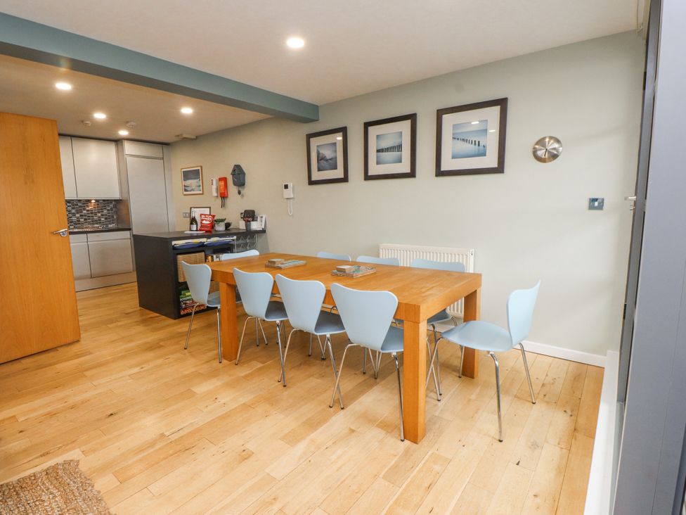 A dining area with a wooden table and chairs at 2 The Quay Pentraeth