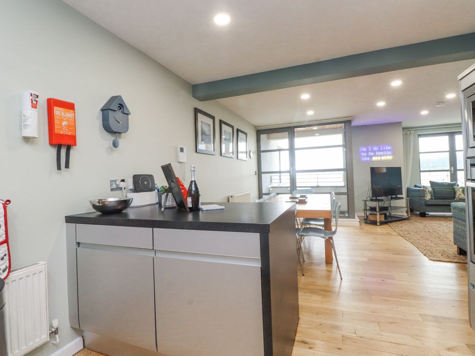 A kitchen with a dining area and living space at 2 The Quay Pentraeth