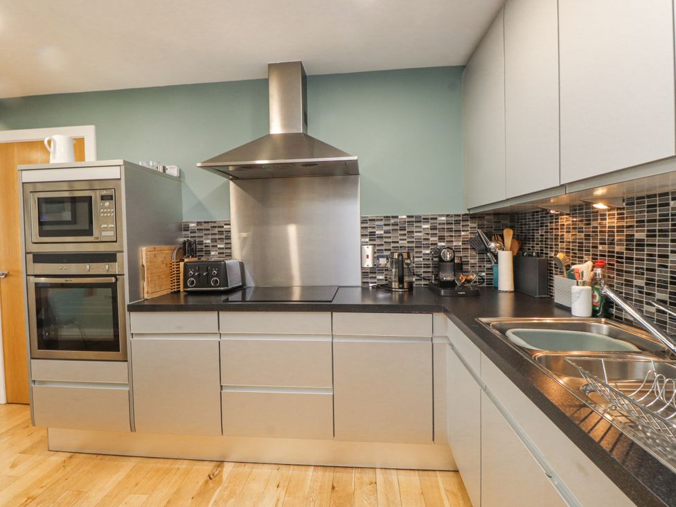 A kitchen with modern appliances and fixtures at 2 The Quay Pentraeth