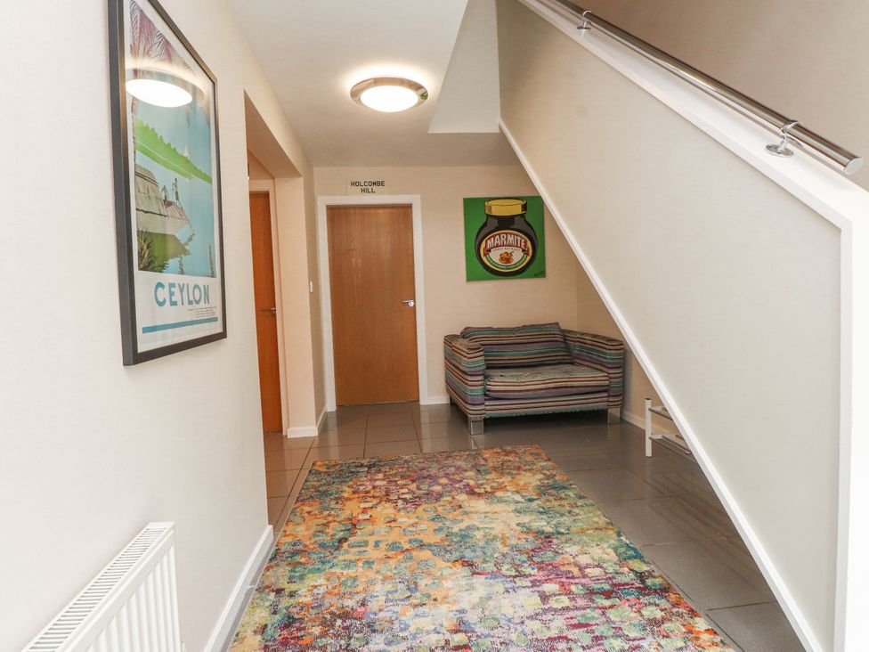 A hallway with a sofa and decorative poster at 2 The Quay Pentraeth