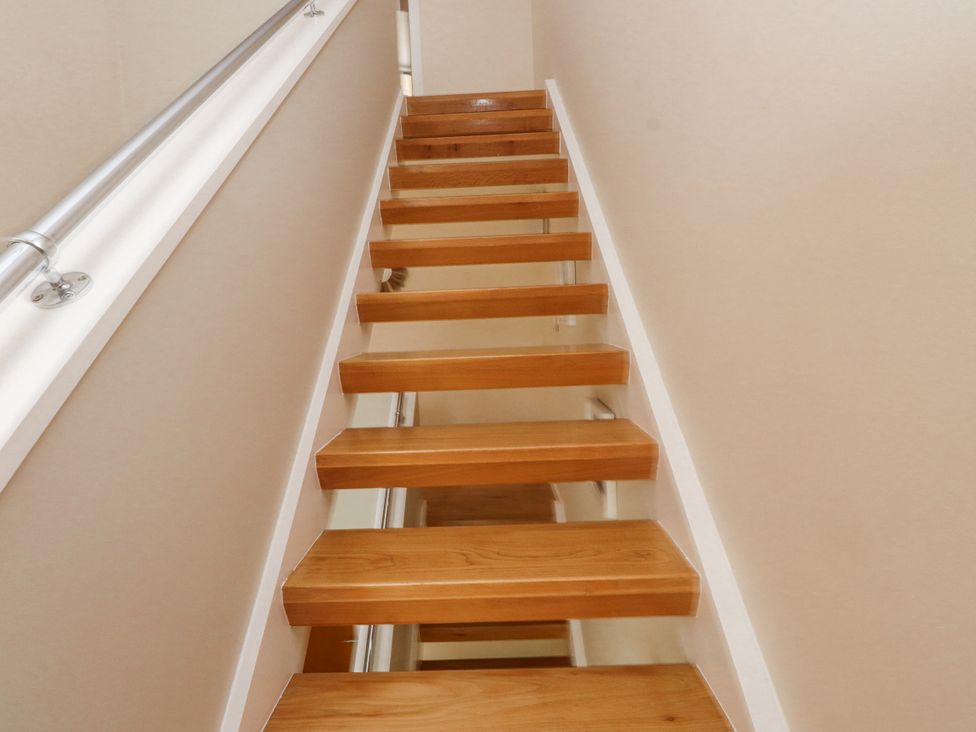 A staircase with wooden steps and a handrail at 2 The Quay Pentraeth