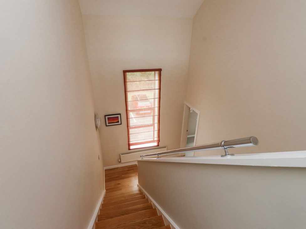 A staircase with wooden steps and a window at 2 The Quay Pentraeth