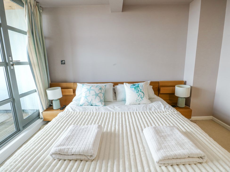 A bedroom with a bed and bedside lamps at 2 The Quay Pentraeth