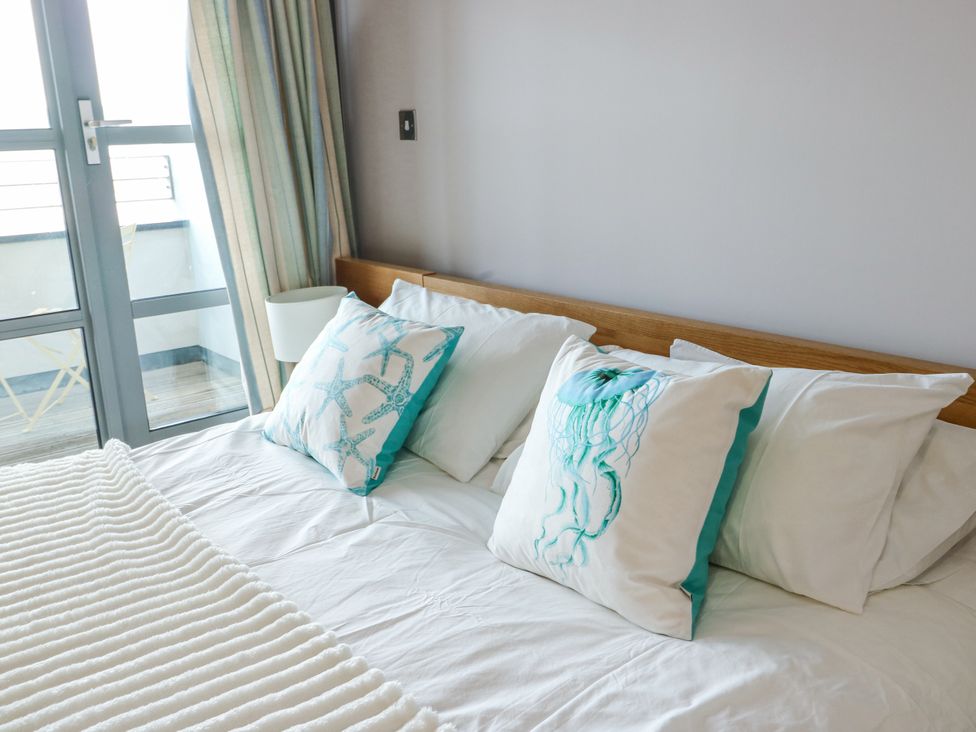 A bedroom with a bed and decorative pillows at 2 The Quay in Pentraeth