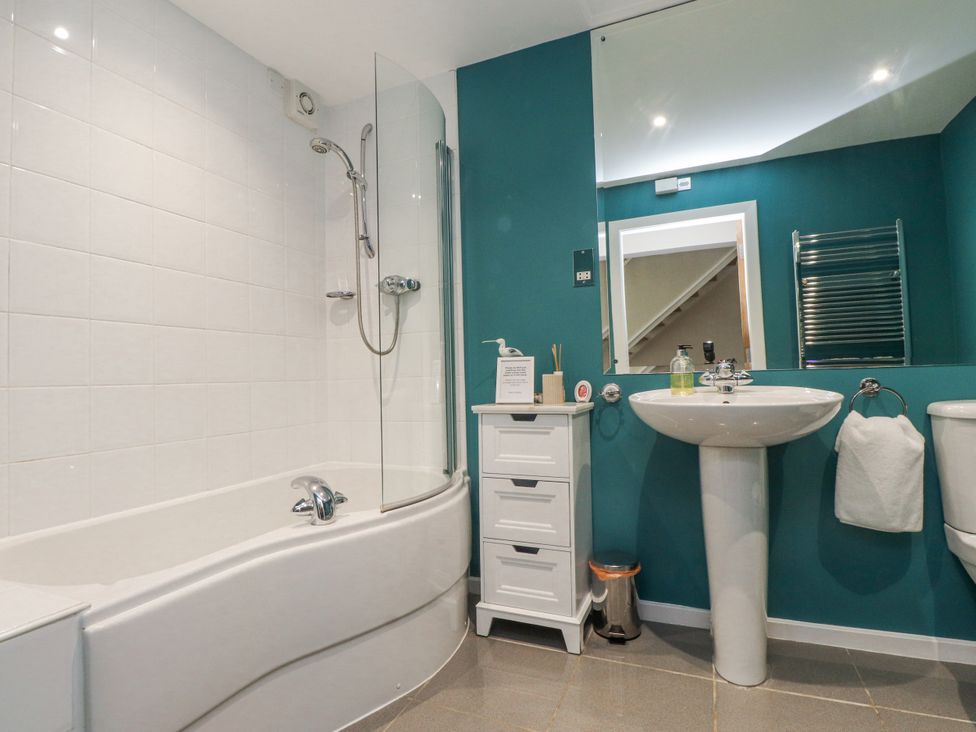 A bathroom with a bathtub, shower, sink, and toilet at 2 The Quay Pentraeth
