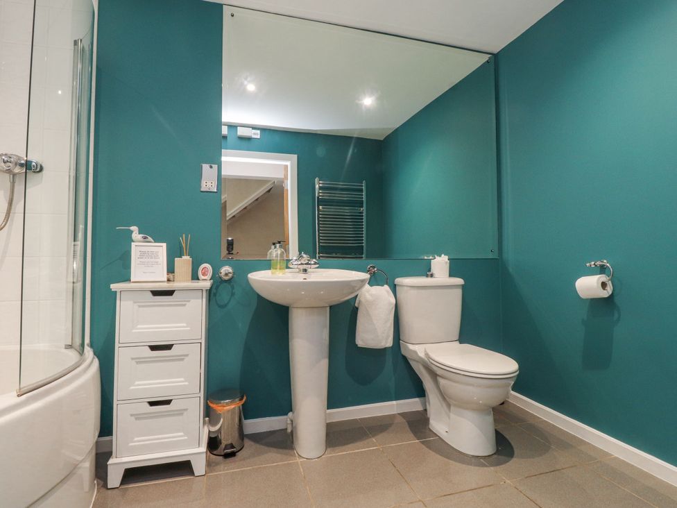 A bathroom with a sink, toilet, and shower at 2 The Quay Pentraeth