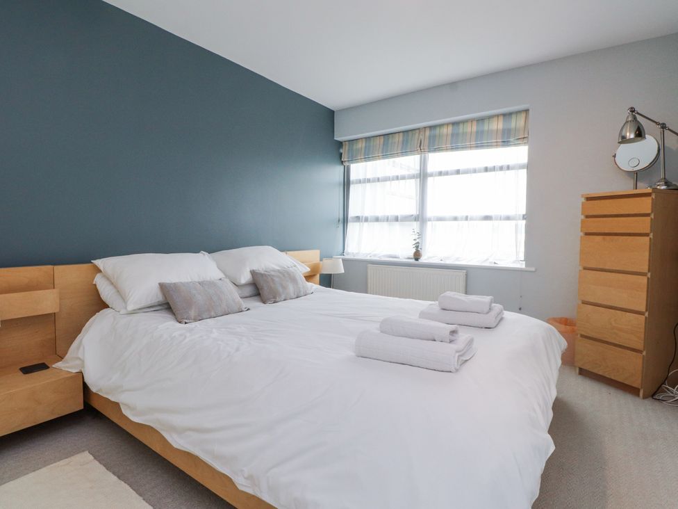 A bedroom with a bed and window at 2 The Quay in Pentraeth