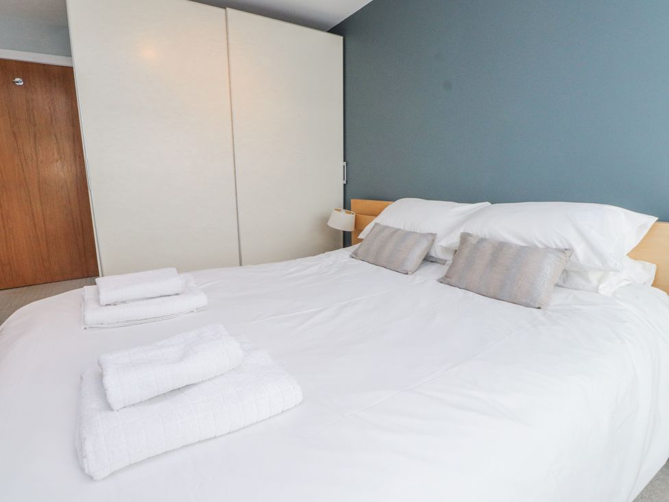 A bedroom with a bed and pillows at 2 The Quay Pentraeth
