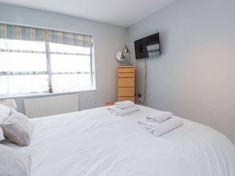 A bedroom with a bed and a television at 2 The Quay Pentraeth