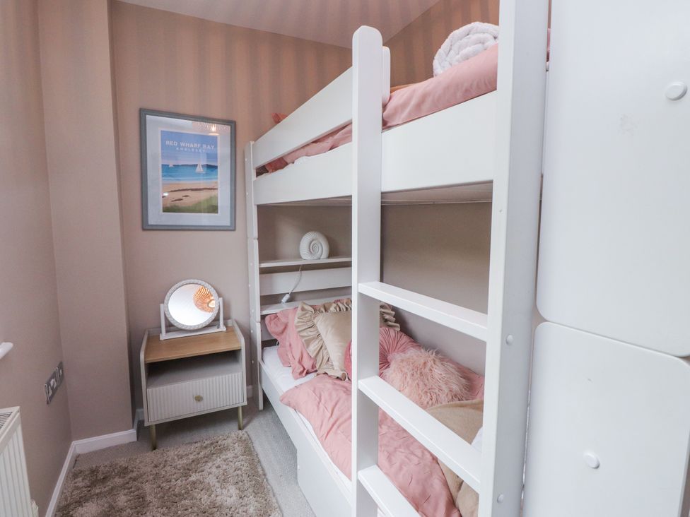 A bedroom with a bunk bed and nightstand at 2 The Quay in Pentraeth