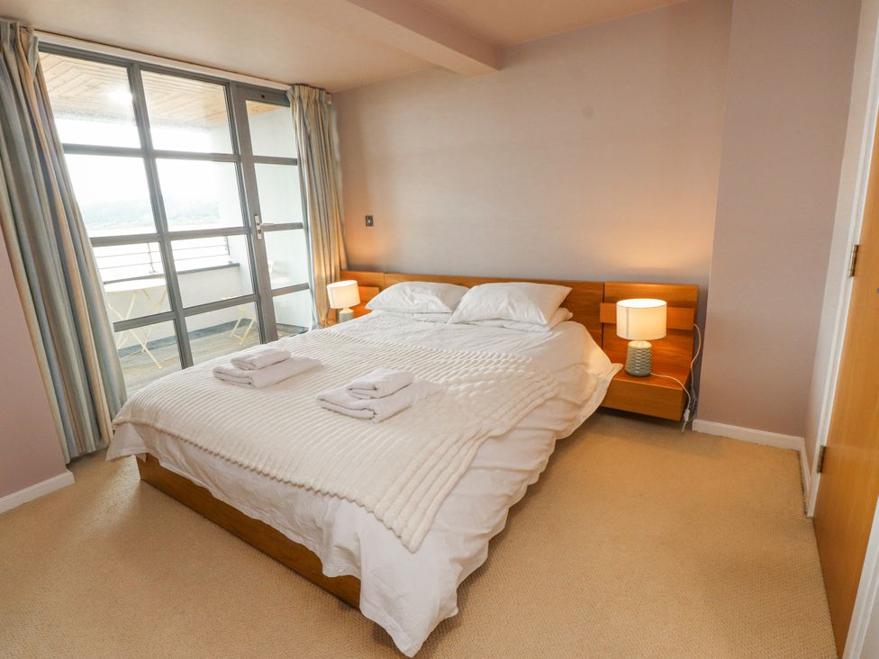 A bedroom with a bed and bedside tables at 2 The Quay Pentraeth