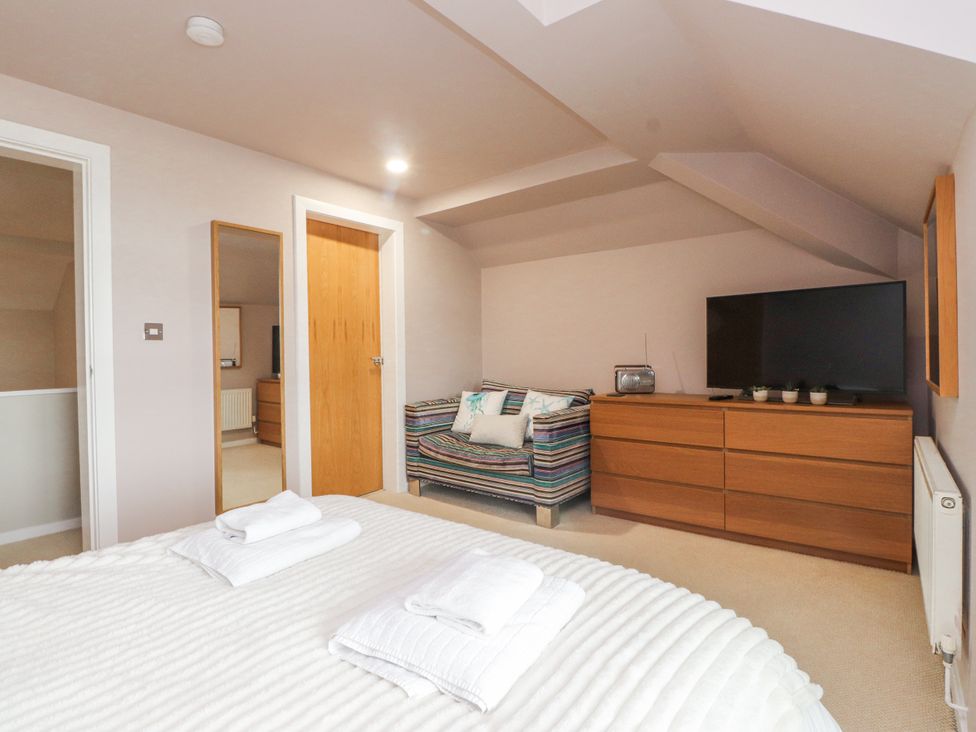 A bedroom with a bed and television at 2 The Quay Pentraeth