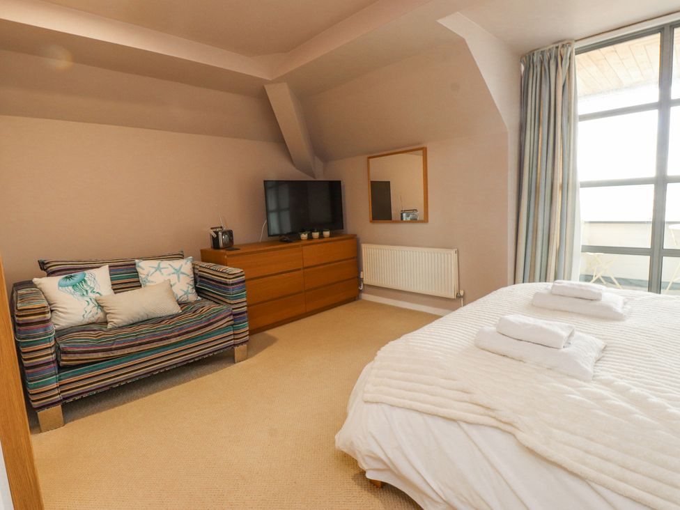 A bedroom with a television, bed, and sofa at 2 The Quay Pentraeth
