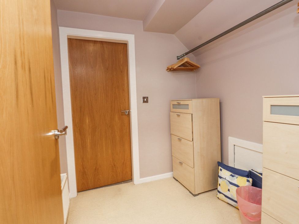 A closet with dressers and hangers at 2 The Quay, Pentraeth