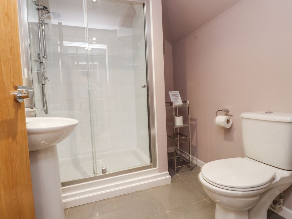 A bathroom with a shower, toilet, and sink at 2 The Quay Pentraeth