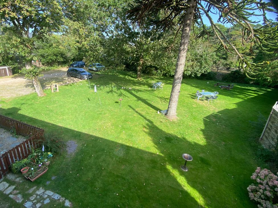 A garden with cars and seating at Garden Flat in Porthmadog