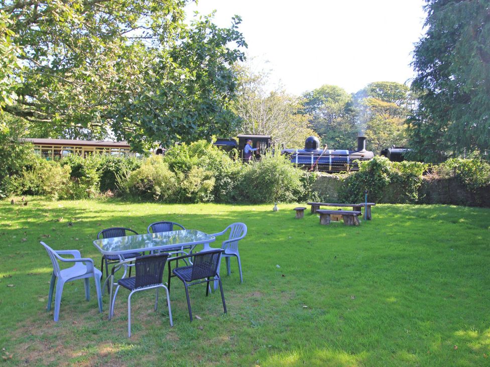 A garden with chairs and a table at Garden Flat Porthmadog