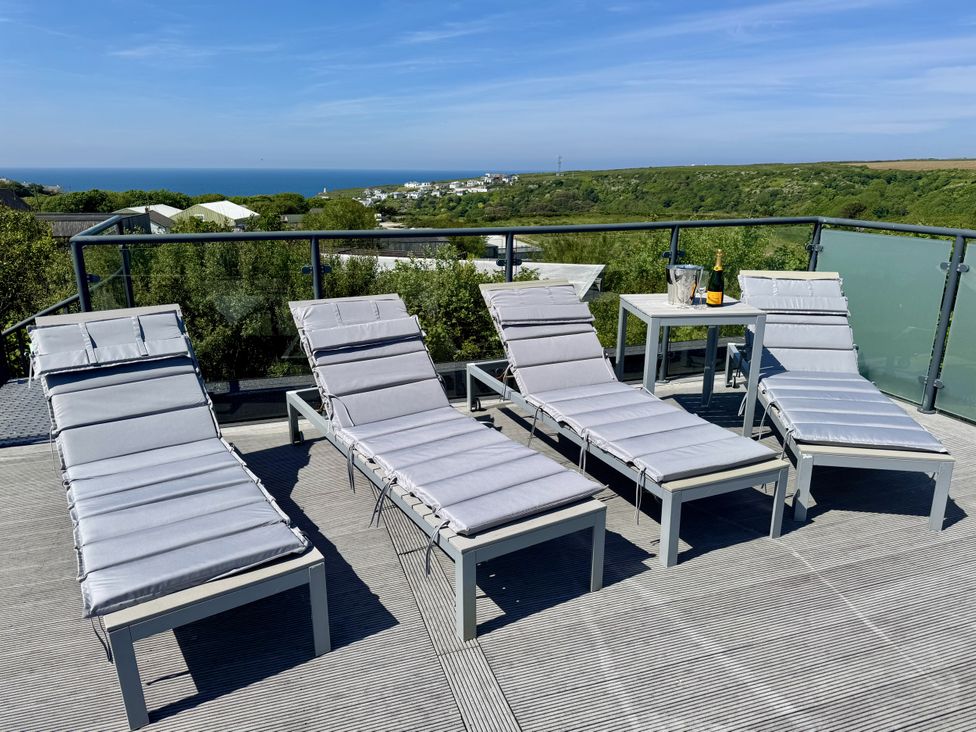 An outdoor area with lounge chairs and a table with champagne at The Black Barnacle in Portreath