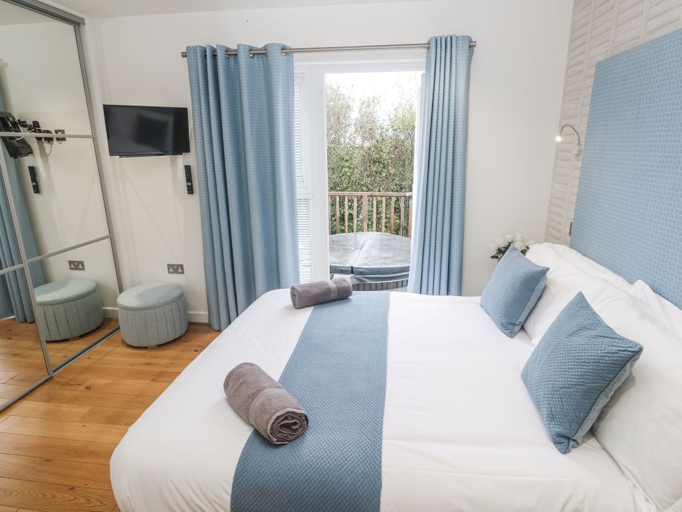 A bedroom with a bed and television at The Black Barnacle in Portreath