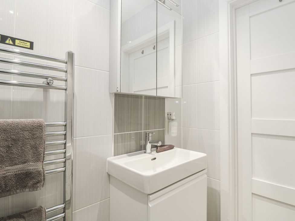 A bathroom with a sink and towel rack at The Black Barnacle in Portreath