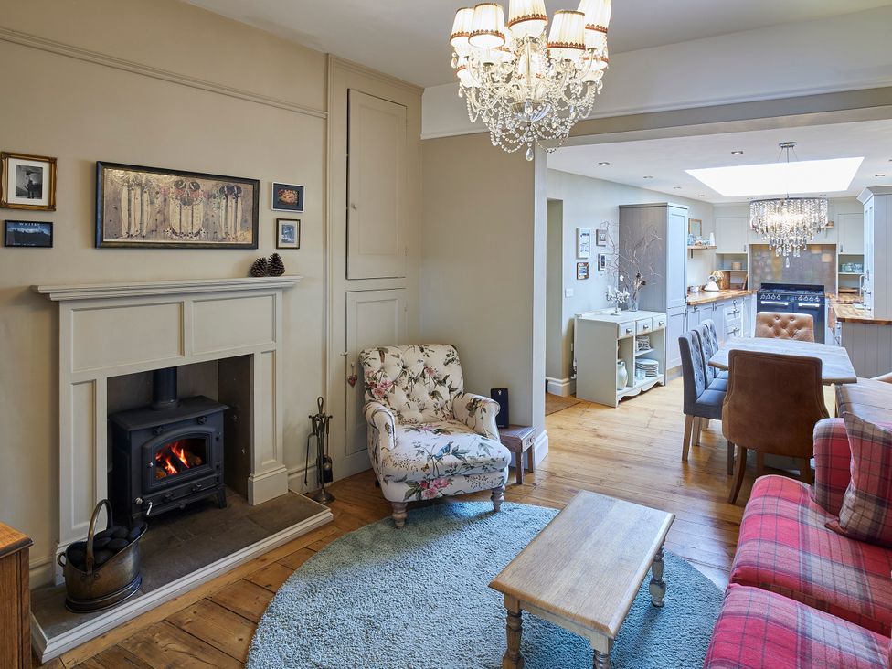 A living room with a fireplace and armchair at Isla House in Whitby