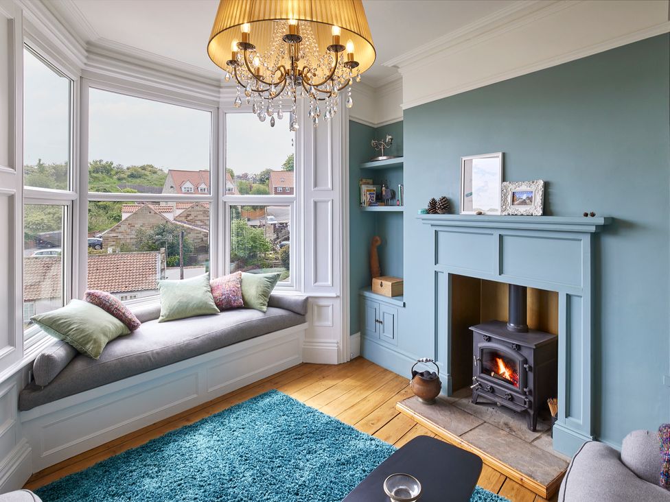 A living room with a fireplace and window seat at Isla House in Whitby