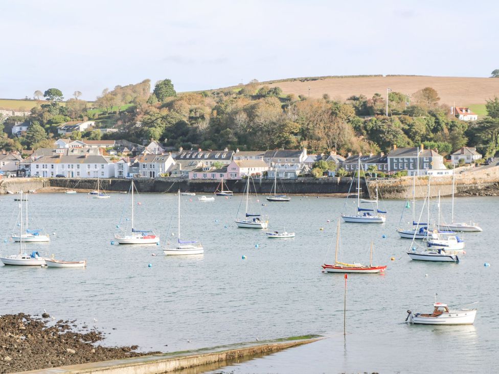 A harbor with multiple sailboats and motorboats on the water near a village with houses and trees at Cottage Annex in Constantine