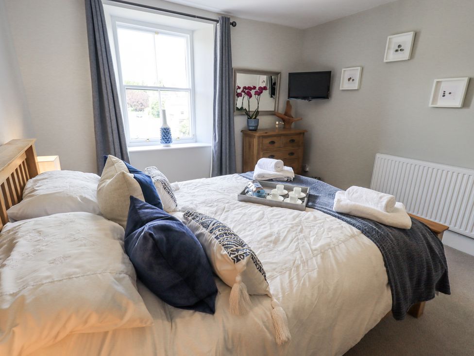 A bedroom with a bed and TV at Olive Cottage in Kirkby Stephen