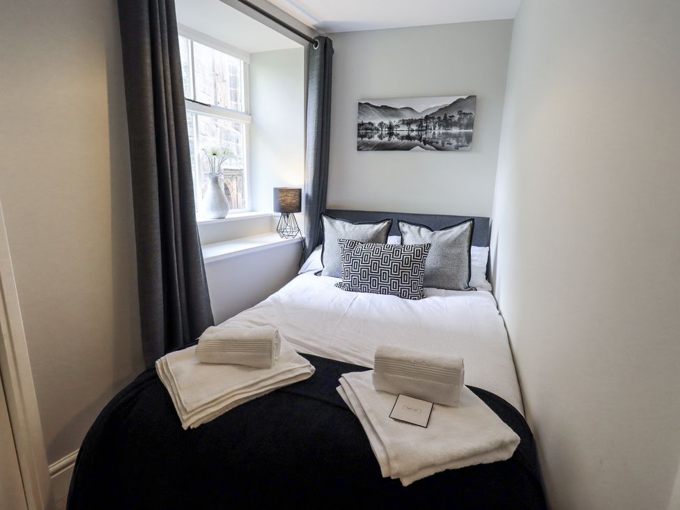 A bedroom with a bed and window at Olive Cottage in Kirkby Stephen