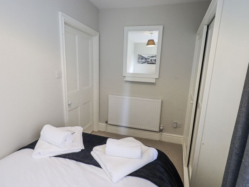 A bedroom with a bed and towels on top at Olive Cottage in Kirkby Stephen