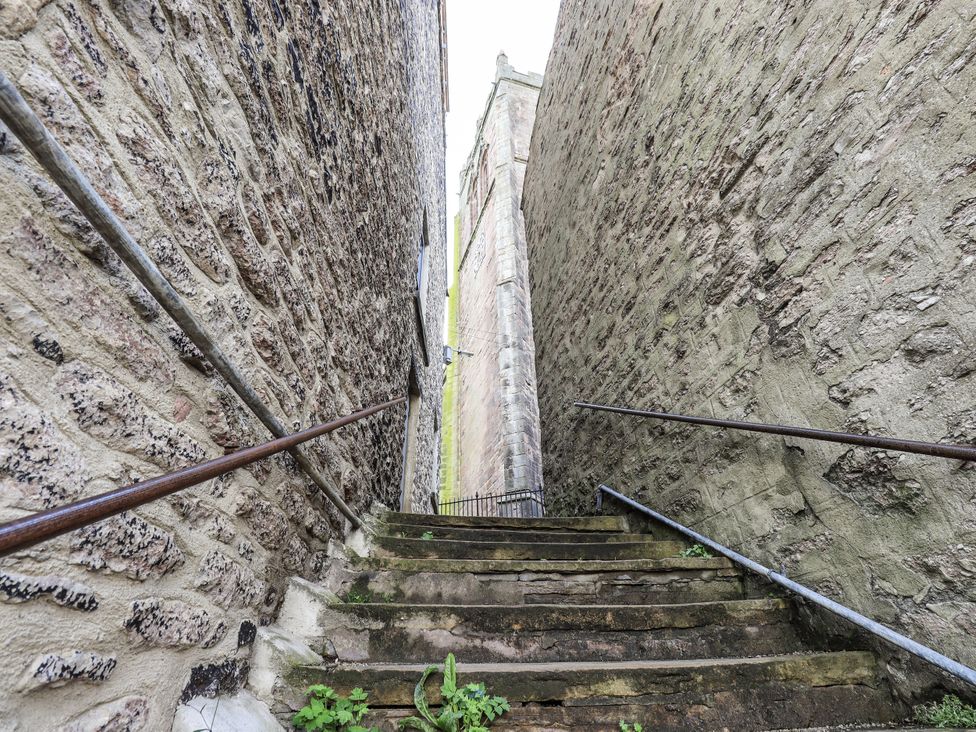 A stairway between stone walls leading to a gate at Olive Cottage in Kirkby Stephen
