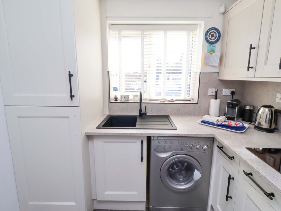 A kitchen with a washing machine and sink at Sea Shore in Seahouses