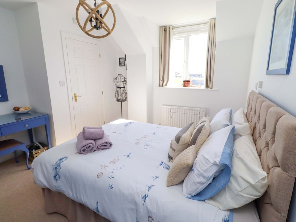 A bedroom with a bed and a dressing table at Sea Shore in Seahouses