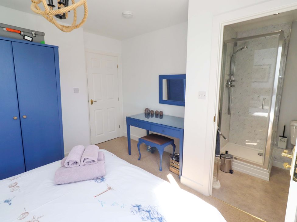 A bedroom with a bed and wardrobe at Sea Shore in Seahouses