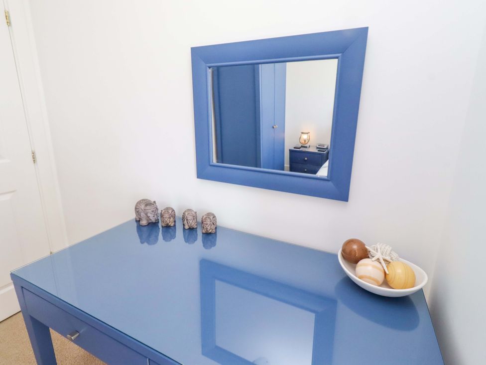 A bedroom with a blue table and mirror at Sea Shore in Seahouses