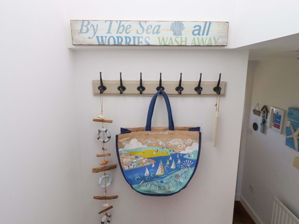 An entryway with a sign and coat hooks at Sea Shore in Seahouses