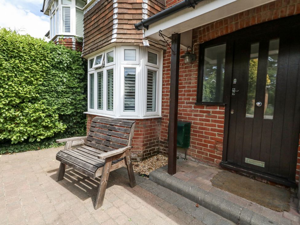 A bench near a window and door at King Henry House in Lymington