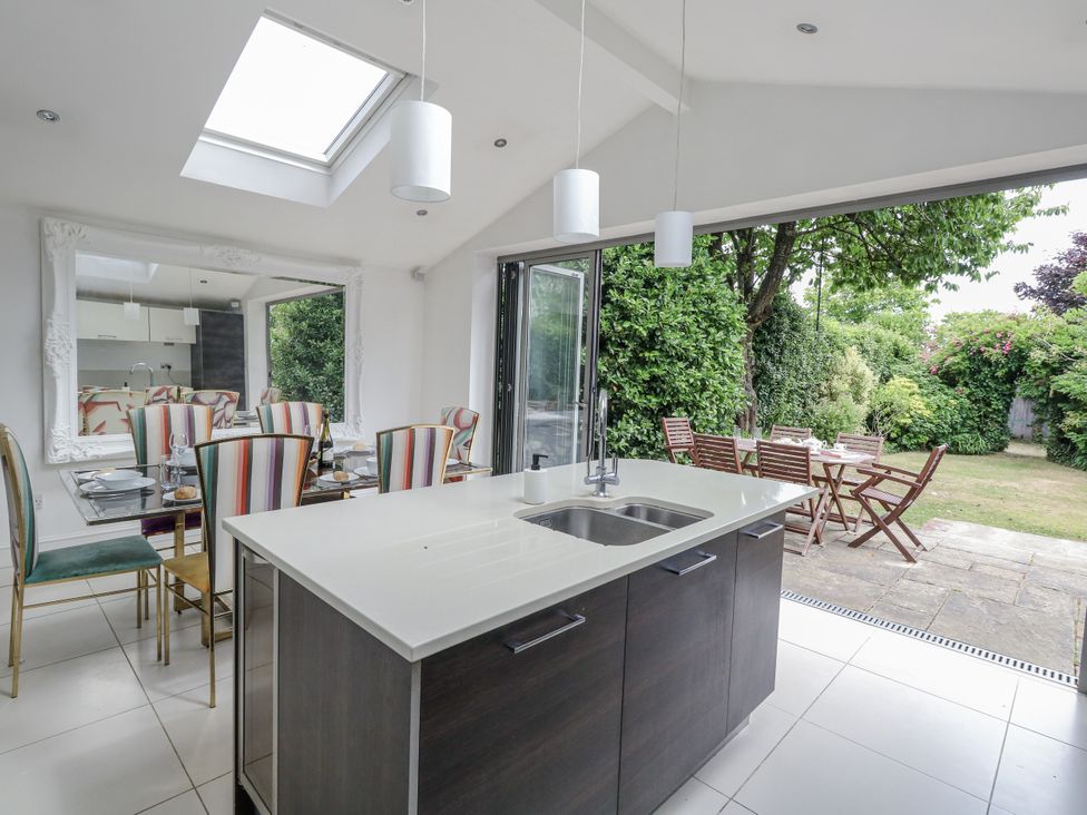 A kitchen with a dining area and garden view at King Henry House in Lymington