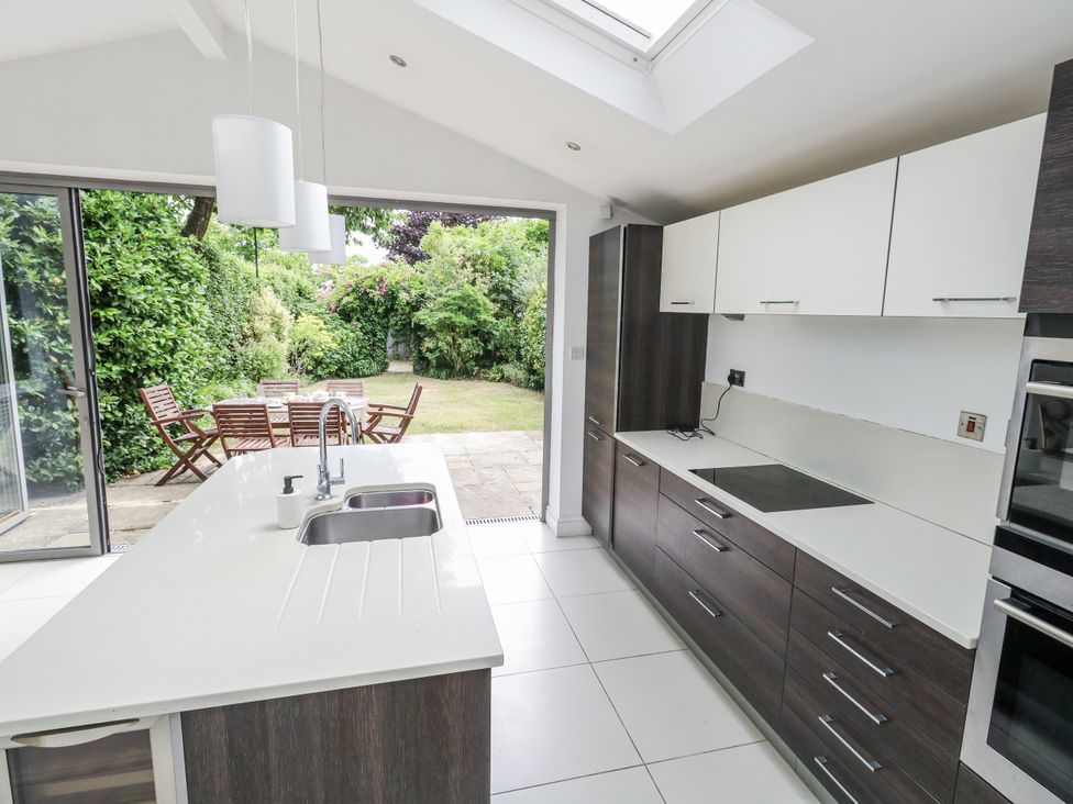 A kitchen with an island and sliding door to a garden at King Henry House in Lymington