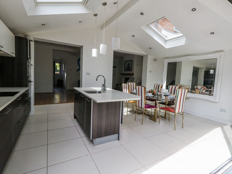A kitchen with an island and dining area at King Henry House Lymington