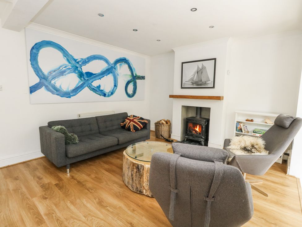 A living room with a sofa, armchairs, coffee table and fireplace at King Henry House, Lymington