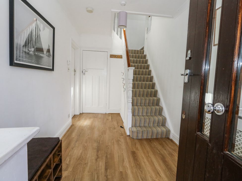 A hallway with a staircase and door at King Henry House in Lymington