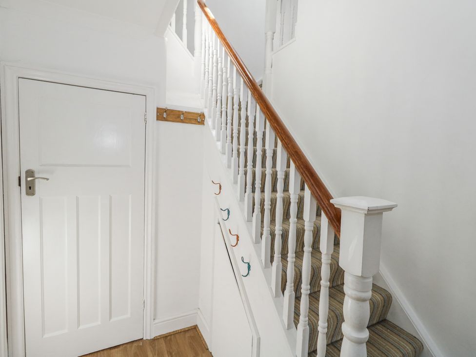 A hallway with a staircase and a door at King Henry House in Lymington