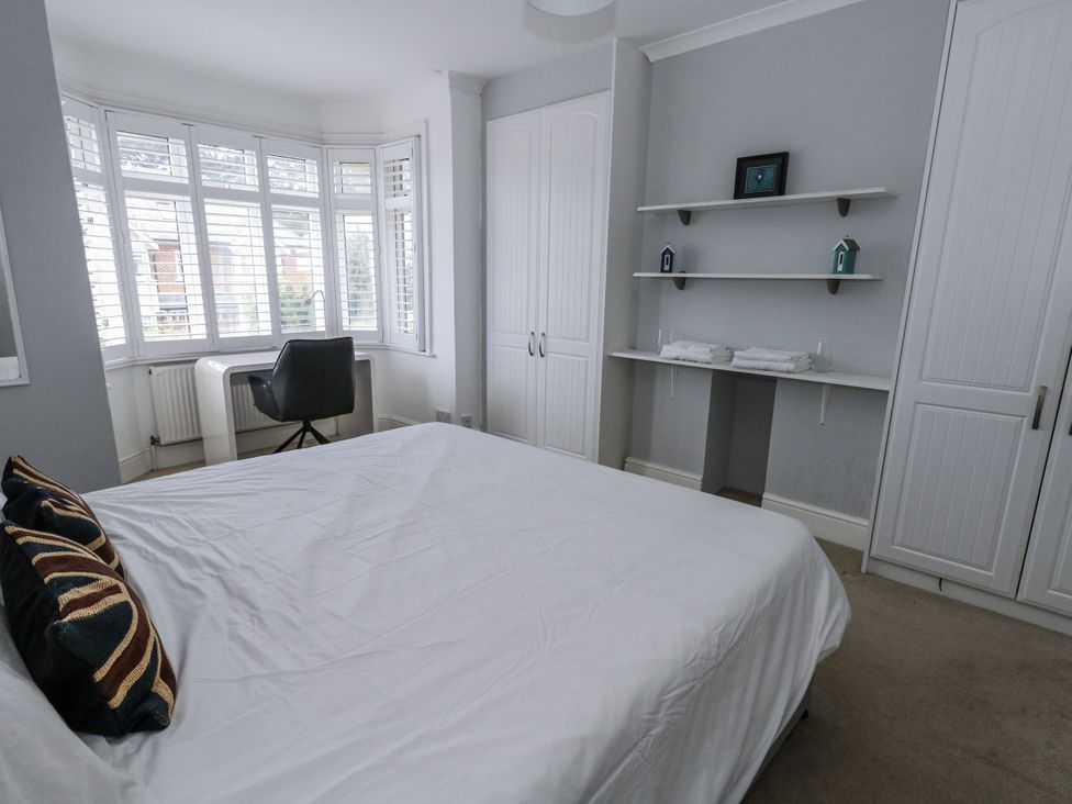 A bedroom with a bed, desk, and wardrobe at King Henry House Lymington
