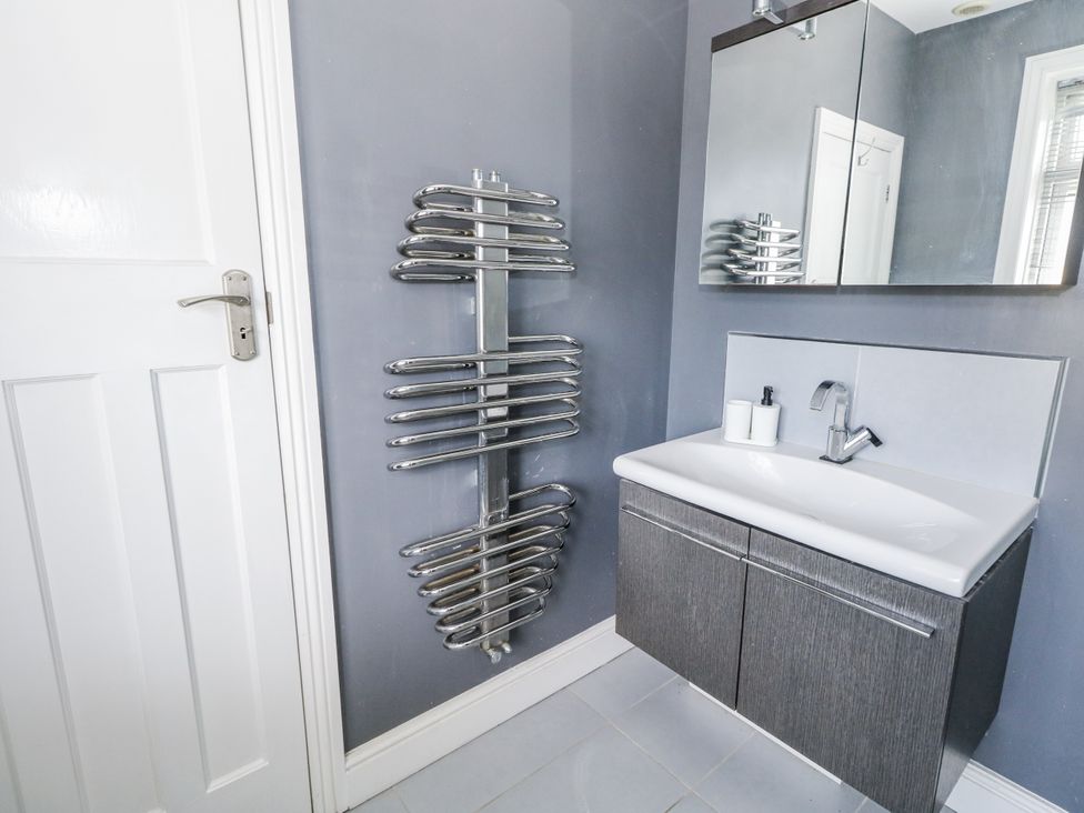 A bathroom with a sink and towel rail at King Henry House in Lymington